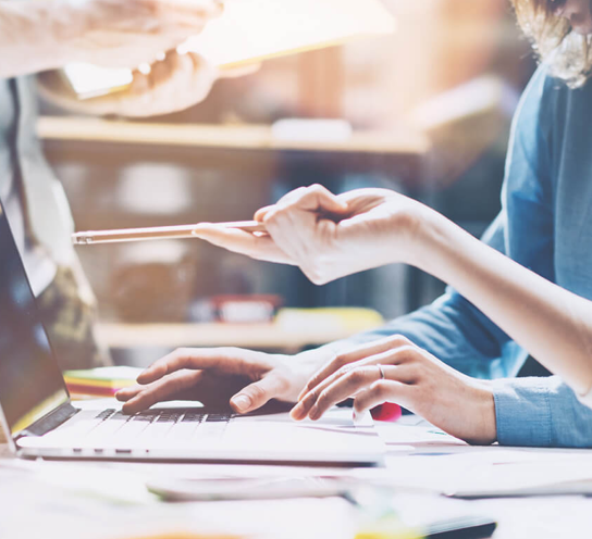 Picture of two people sitting in front of a laptop